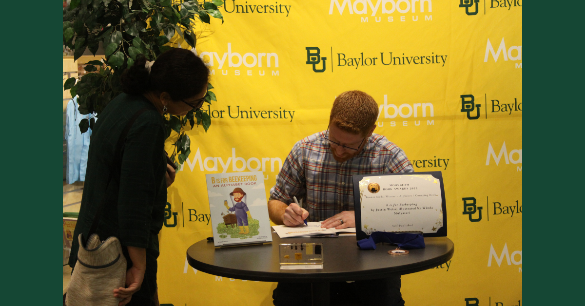 Author Justin Weiss signing books at Baylor University.